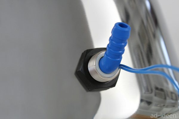 Detailaufnahme eines Wasseranschlusses mit blauer Schlauchverbindung, ideal für mobile Wasserversorgungssysteme im Camping- und Outdoor-Bereich. Perfekt geeignet für den Einbau in Transportern oder Marktständen, um fließendes Wasser bereitzustellen.