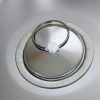 Detailaufnahme eines Edelstahl-Waschbeckens mit einem weißen Abflussstopfen, ideal für mobile Wasserversorgungslösungen im Campingbereich. Perfekt geeignet für den Einbau in Bullis oder Transportern, um frisches Wasser bereitzustellen.
