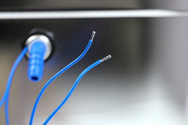 Detailaufnahme von blauen Kabeln, die für die Installation von mobilen Wasserversorgungssystemen verwendet werden, ideal für Campingbedarf und Fahrzeugumbauten wie Bullis oder Transporter.